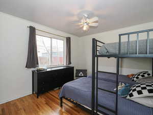 Bedroom with wood-type flooring, a ceiling fan, and crown molding