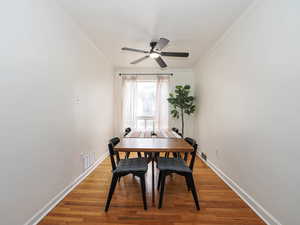 Dining area with light wood-type flooring, ceiling fan, and crown molding