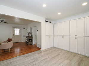Interior space with light wood finished floors, ornamental molding, recessed lighting, and a ceiling fan