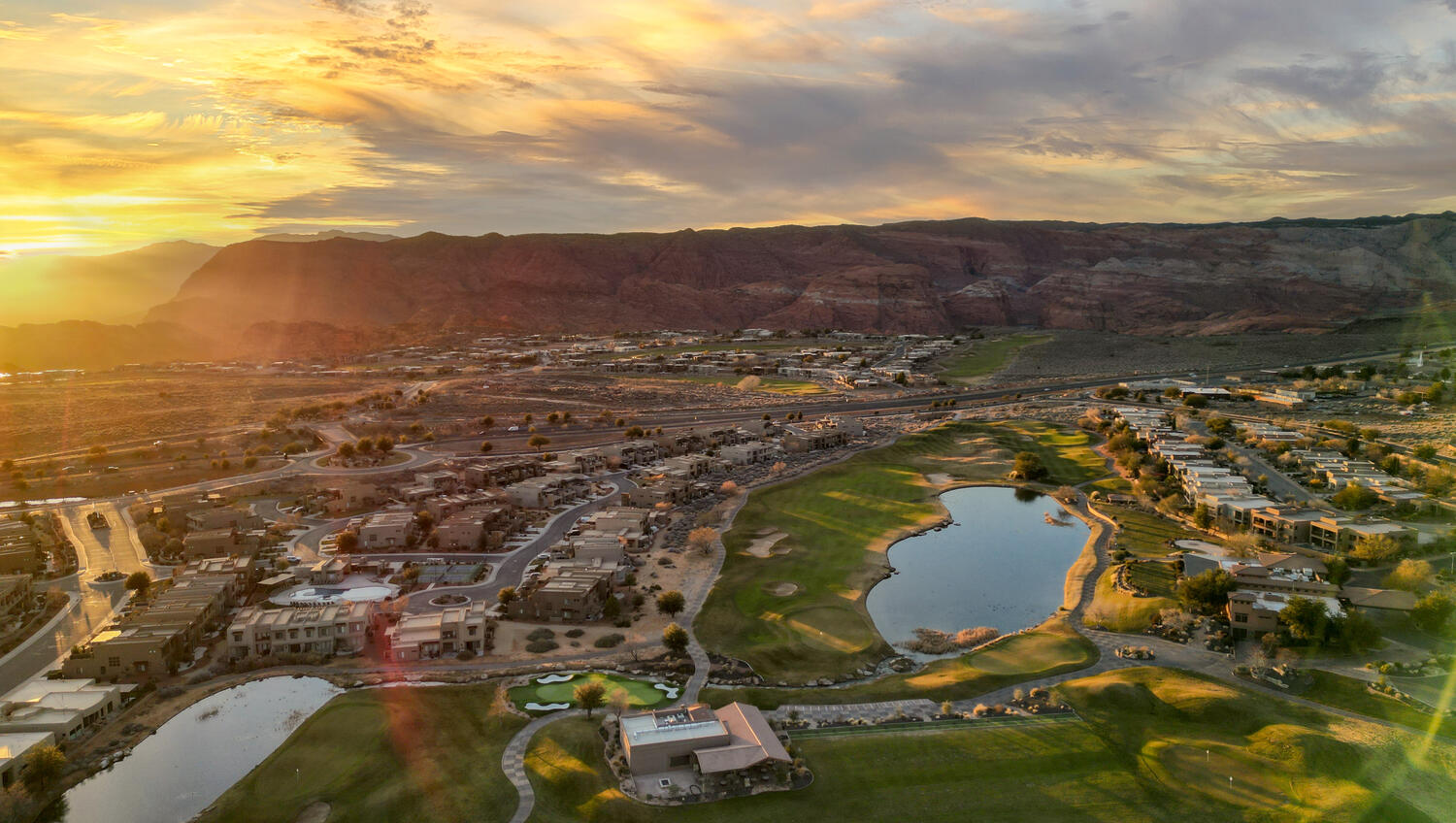 Aerial view at dusk of a water and mountain view, view of golf course, and a residential view