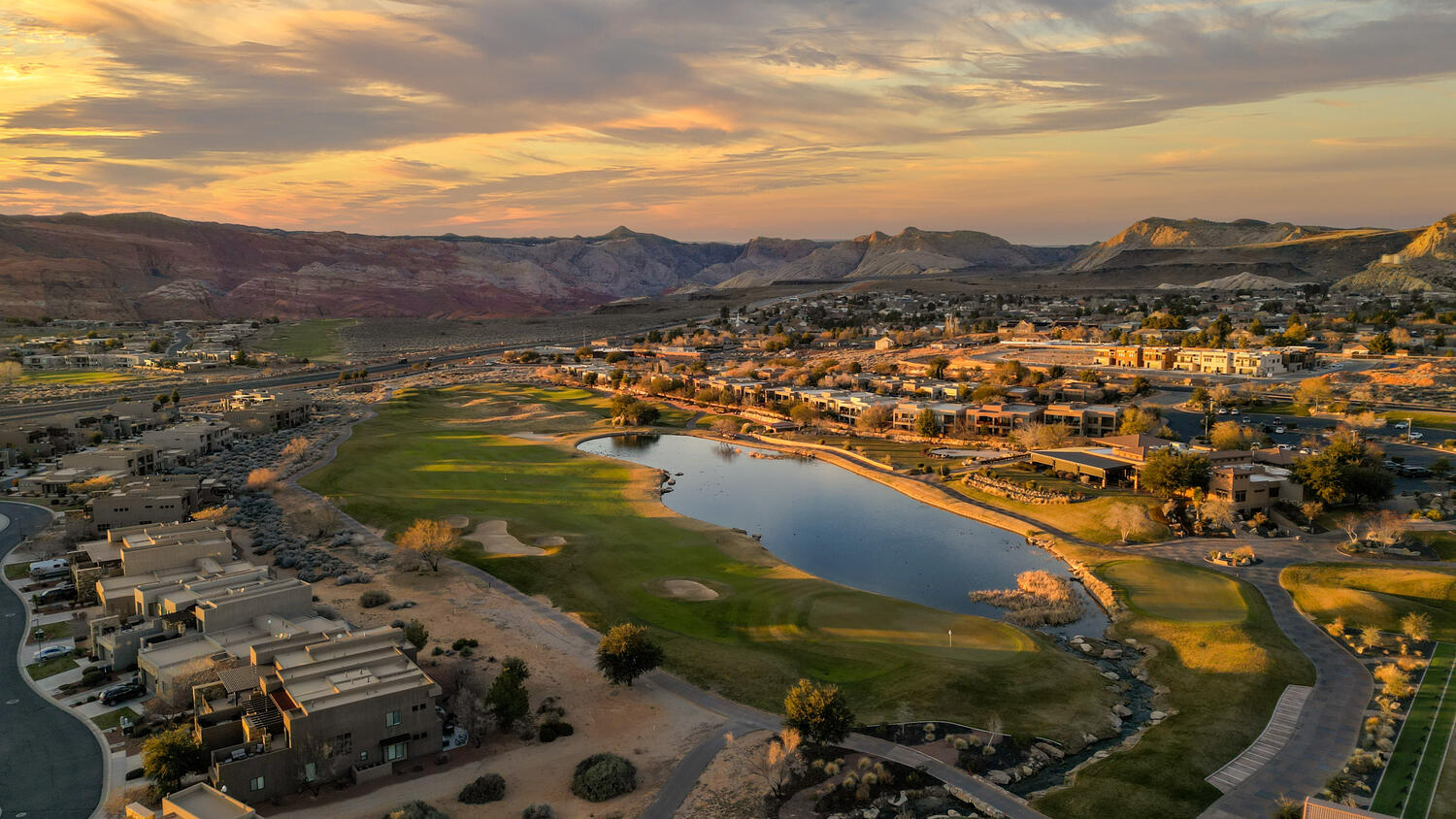 Aerial perspective of suburban area with a water and mountain view and a golf course