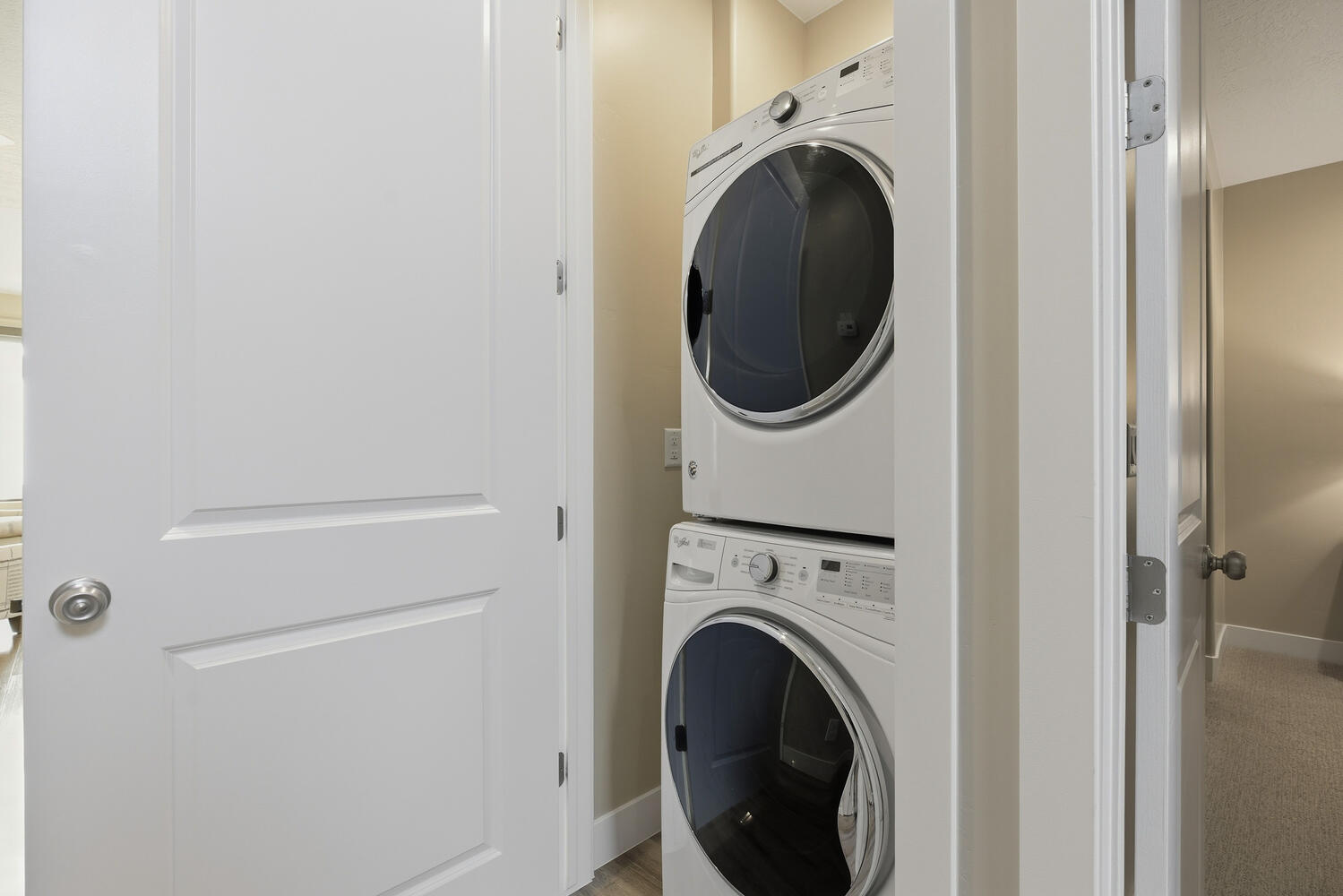 Laundry area featuring stacked washing machine and dryer and baseboards