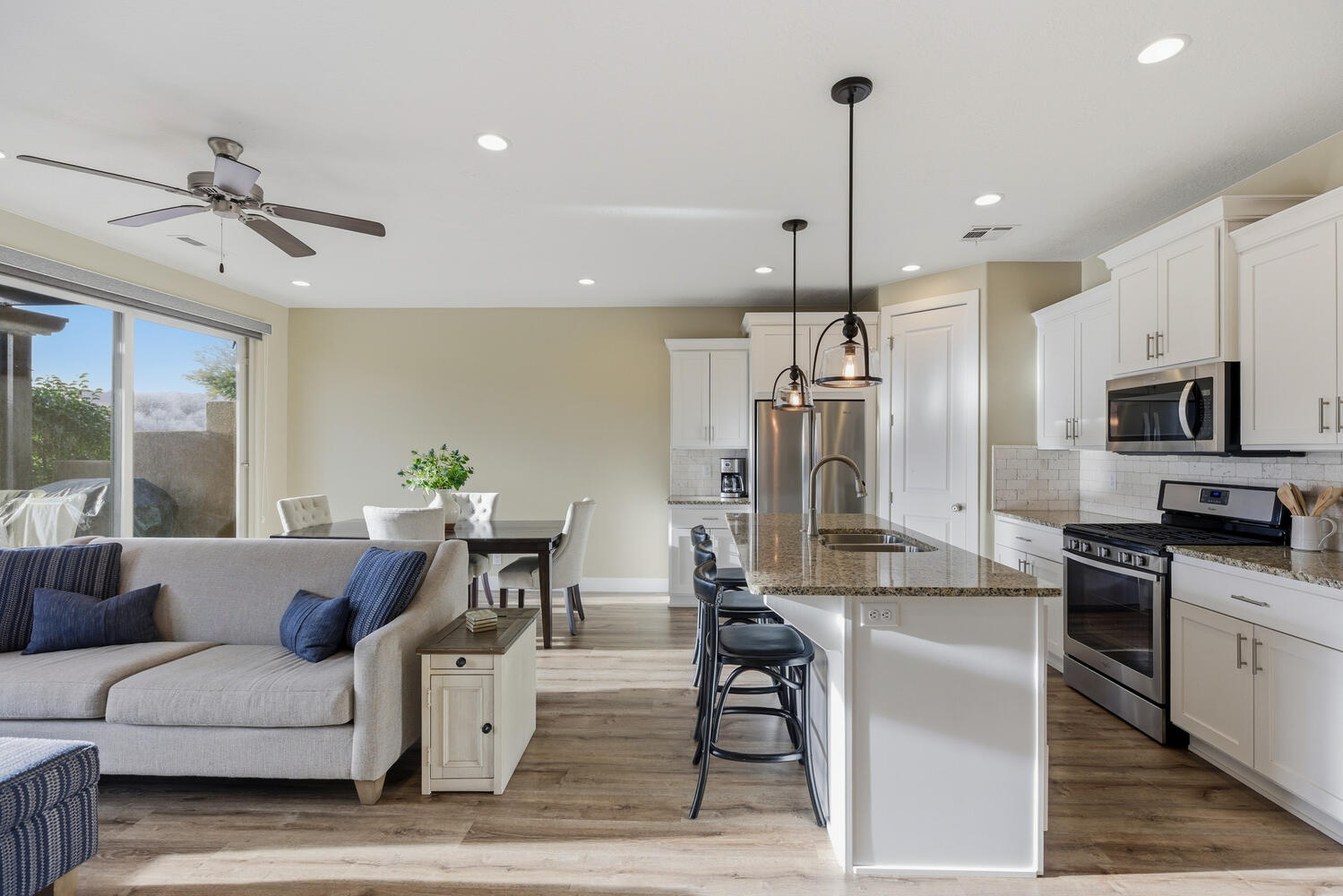 Kitchen with open floor plan, stainless steel appliances, white cabinets, and a breakfast bar