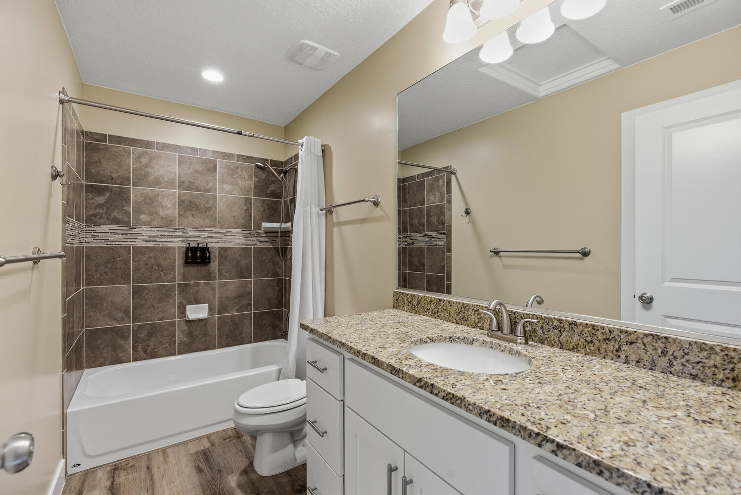 Bathroom with shower / tub combo, vanity, and light wood-style floors