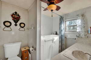 Bathroom with vanity, tile walls, a walkin tub to relax in, ceiling fan, and a shower with shower curtain