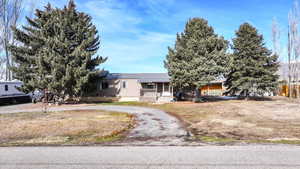 View of front of home featuring a porch, a front lawn, and curved driveway