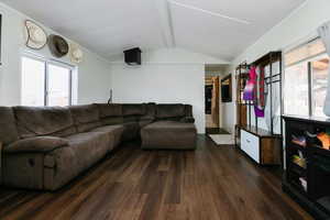 Living area featuring beamed ceiling and dark wood finished floors