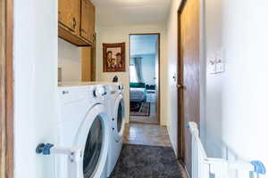 Laundry area with light colored carpet, independent washer and dryer, and cabinet space