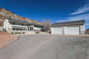 View of front of home with stone siding, board and batten siding, an outbuilding, a detached garage, and a mountain view