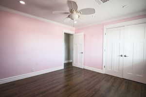 Unfurnished bedroom with ornamental molding, dark wood-type flooring, a closet, a ceiling fan, and recessed lighting