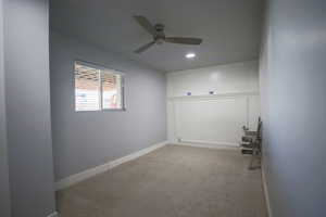 Carpeted spare room featuring a ceiling fan and recessed lighting