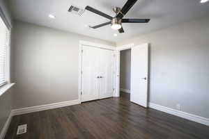 Unfurnished bedroom with dark wood-style floors, a ceiling fan, a closet, and recessed lighting