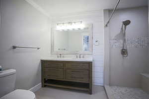 Primary bathroom with double vanity, tiled double shower, light tile patterned floors, and ornamental molding