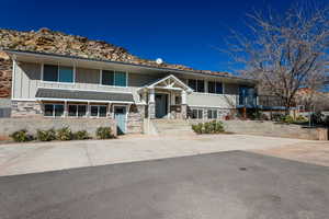 Bi-level home featuring stone siding and board and batten siding