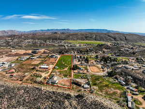 Aerial view of residential area featuring property boundaries highlighted and a mountain backdrop