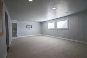 Unfurnished room featuring light carpet, a textured ceiling, and recessed lighting