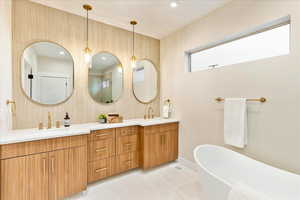 Full bath with double vanity, a soaking tub, and recessed lighting