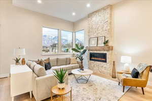 Living area featuring light wood-style flooring, a fireplace, recessed lighting, and a mountain view
