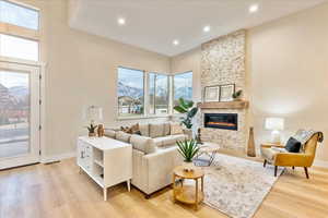 Living area with light wood-luxury vinyl flooring, a fireplace, a mountain view, and recessed lighting