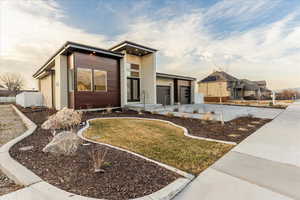 Modern home featuring concrete driveway and an attached garage