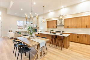 Kitchen featuring wood finish cabinets, a center island with seating and light LVP flooring
