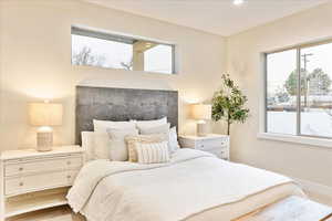 Primary bedroom with multiple windows and recessed lighting