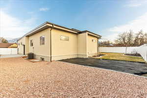 View of side of home featuring a fenced backyard and stucco siding