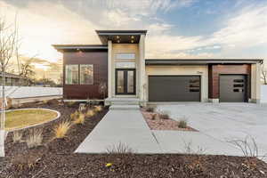 Modern home featuring a garage, driveway, and french doors