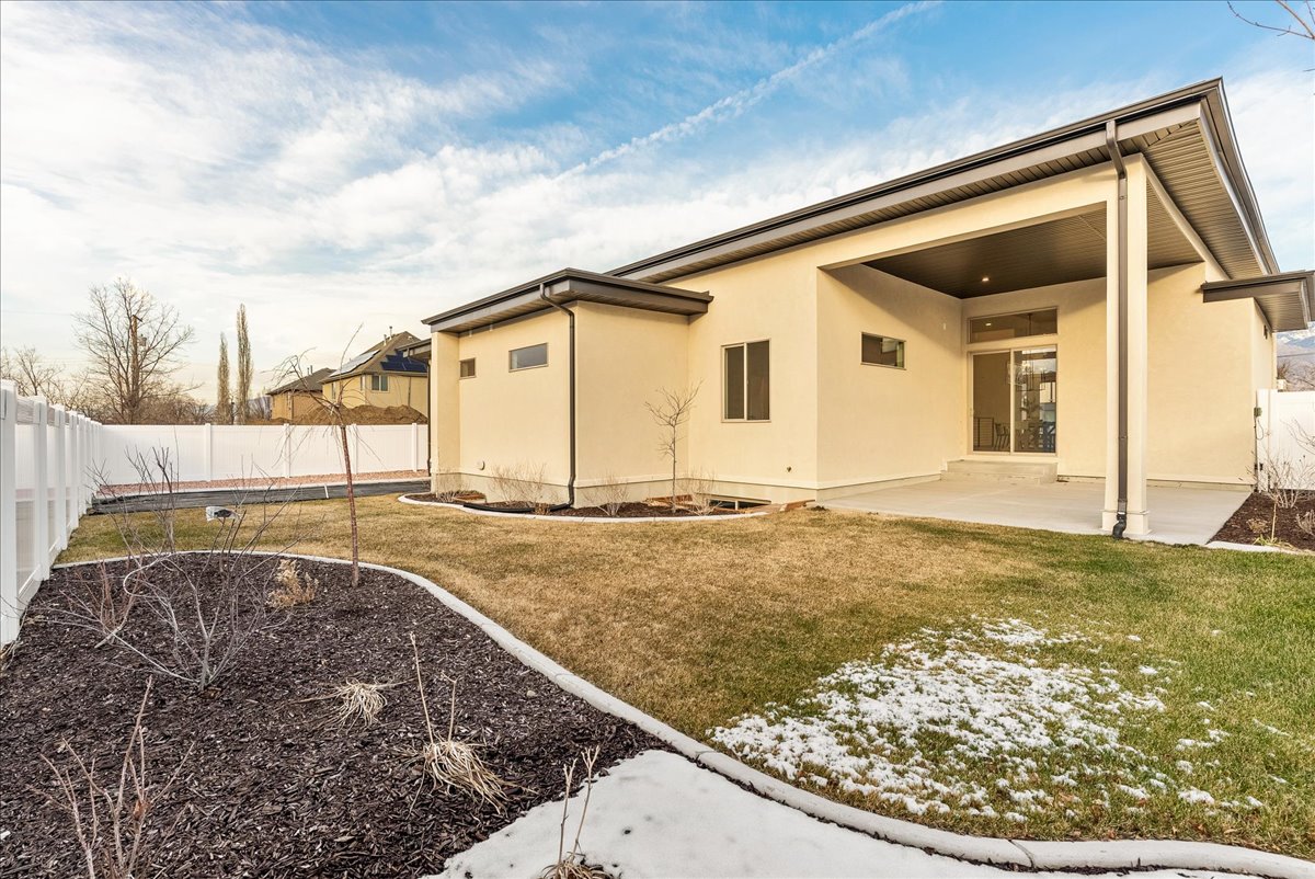 Back of property with stucco siding, a fenced backyard, and a patio area
