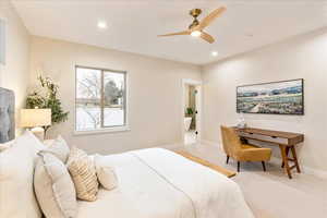 Primary bedroom with a ceiling fan and recessed lighting