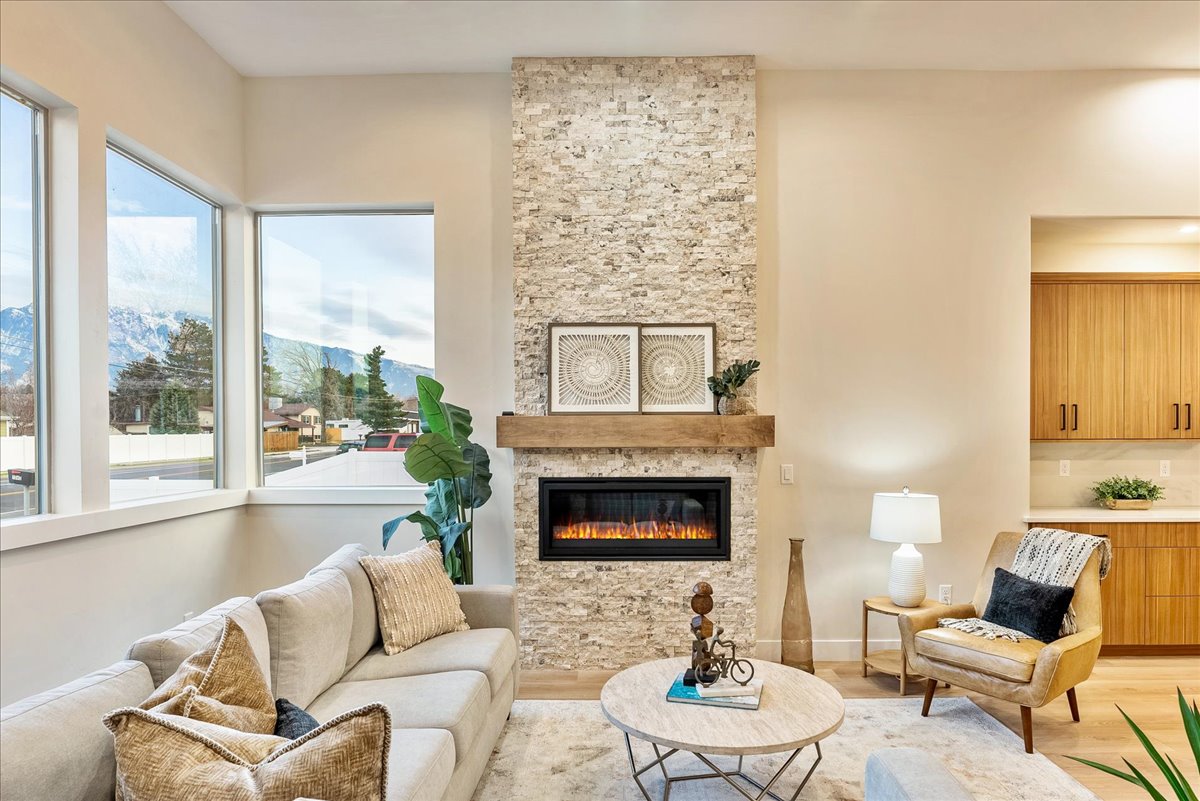 Living room featuring wood finished floors, a mountain view, and a stone fireplace