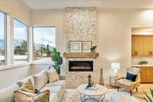 Living room featuring wood finished floors, a mountain view, and a stone fireplace
