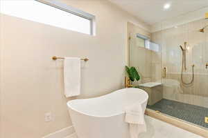 Full bathroom with an oversized shower, a soaking tub, and tile patterned floors