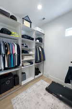 Walk in closet with light wood-type flooring
