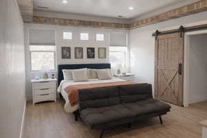Bedroom featuring a barn door and light wood finished floors