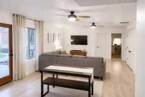 Living room with light wood-style flooring and ceiling fan