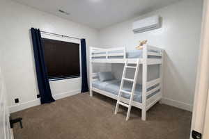 Carpeted bedroom featuring a mini split for heating / cooling and baseboards