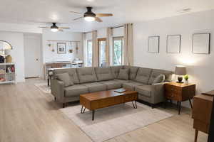 Living area featuring ceiling fan and light wood-type flooring