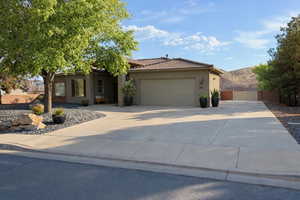 Ranch-style house with stucco siding, concrete driveway, a garage, a tiled roof, and a mountain view