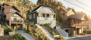 View of front of home with stairs and a residential view