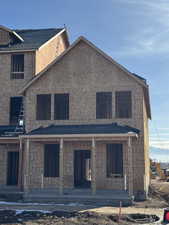 Back of house featuring covered porch and stucco siding
