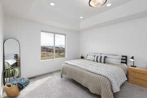 Bedroom featuring carpet, a raised ceiling, recessed lighting, and a mountain view
