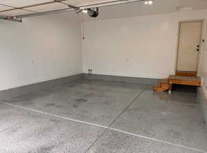 Garage with a garage door opener and baseboards