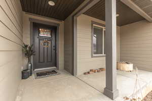 Doorway to property featuring covered porch