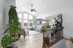 Living room with wood finished floors, lofted ceiling, a ceiling fan, and recessed lighting