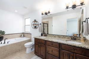 Bathroom with a shower stall, double vanity, a bath, and recessed lighting