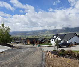 View of asphalt road featuring a mountain view and a residential view