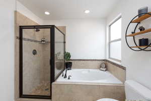 Bathroom featuring a shower stall, a bath, and recessed lighting