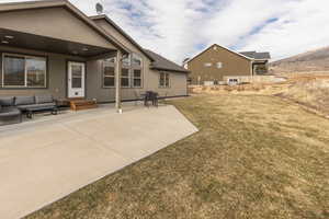Rear view of property with a patio, an outdoor lounge area, and a yard