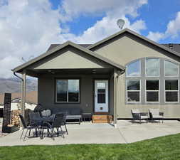Back of property with a patio area, stucco siding, outdoor dining area, and a yard